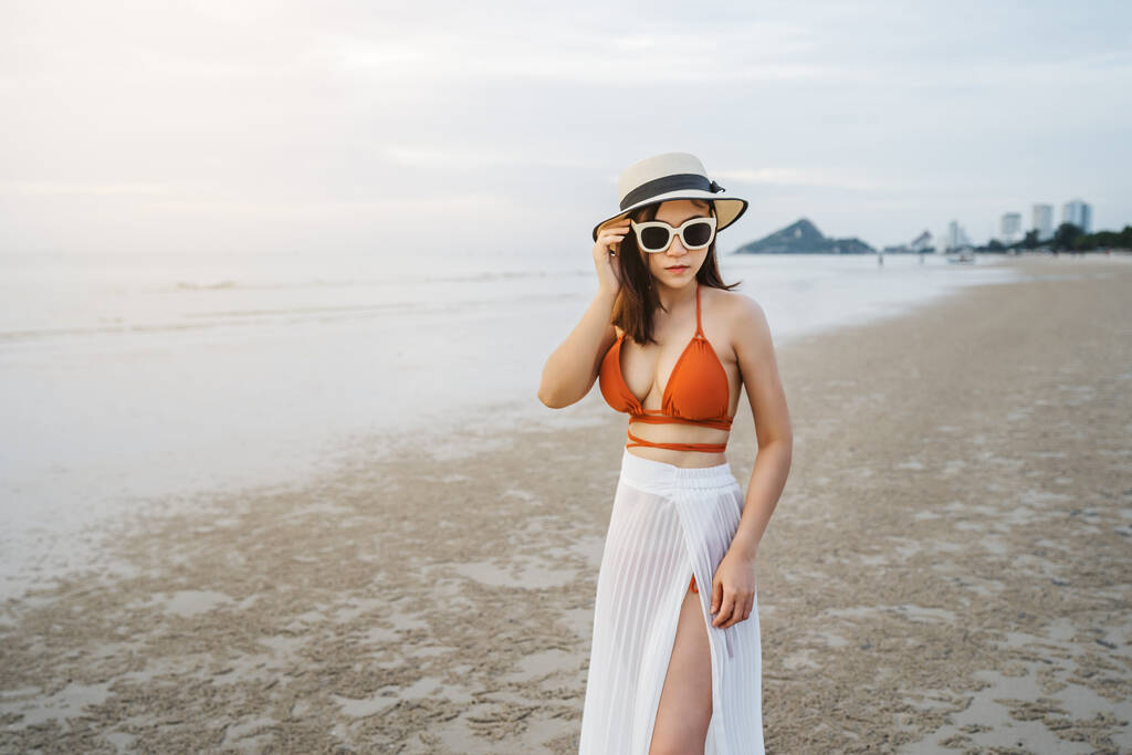 mujer alegre en bikini de pie en la playa del mar - Foto, Imagen