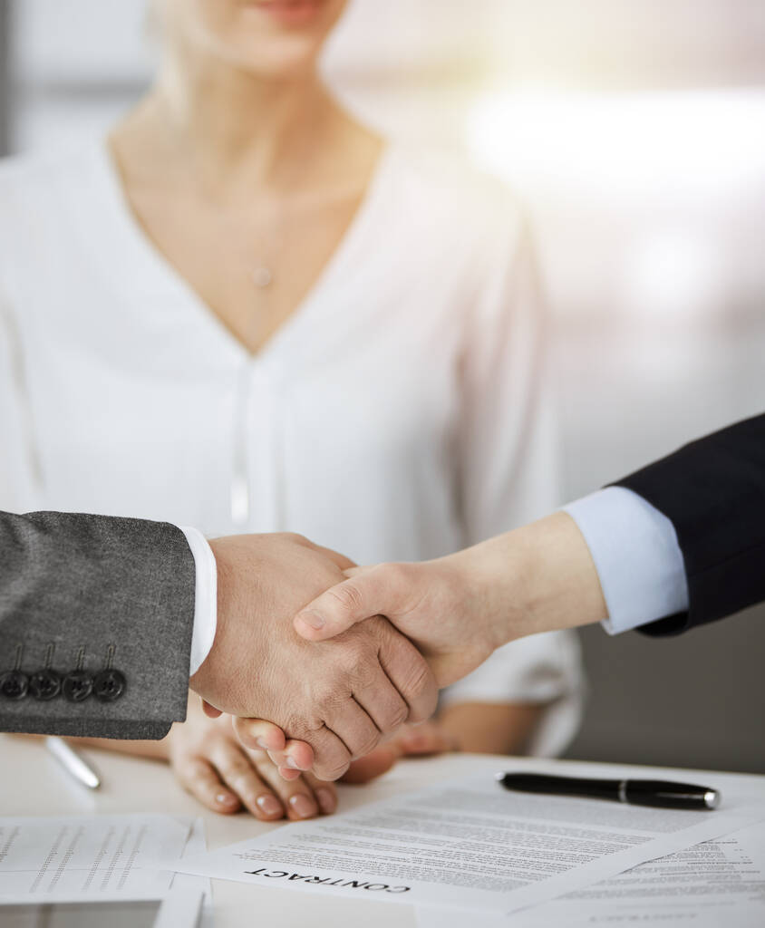 Podnikatelé si potřásají rukama a podepisují kontrakt ve slunné kanceláři, zblízka. Potřesení rukou a marketing - Fotografie, Obrázek