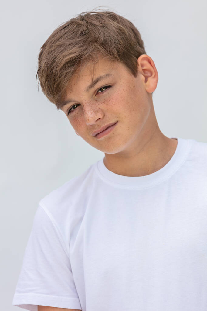 wit achtergrond studio portret van een jongen tiener tiener man kind dragen een wit t-shirt - Foto, afbeelding