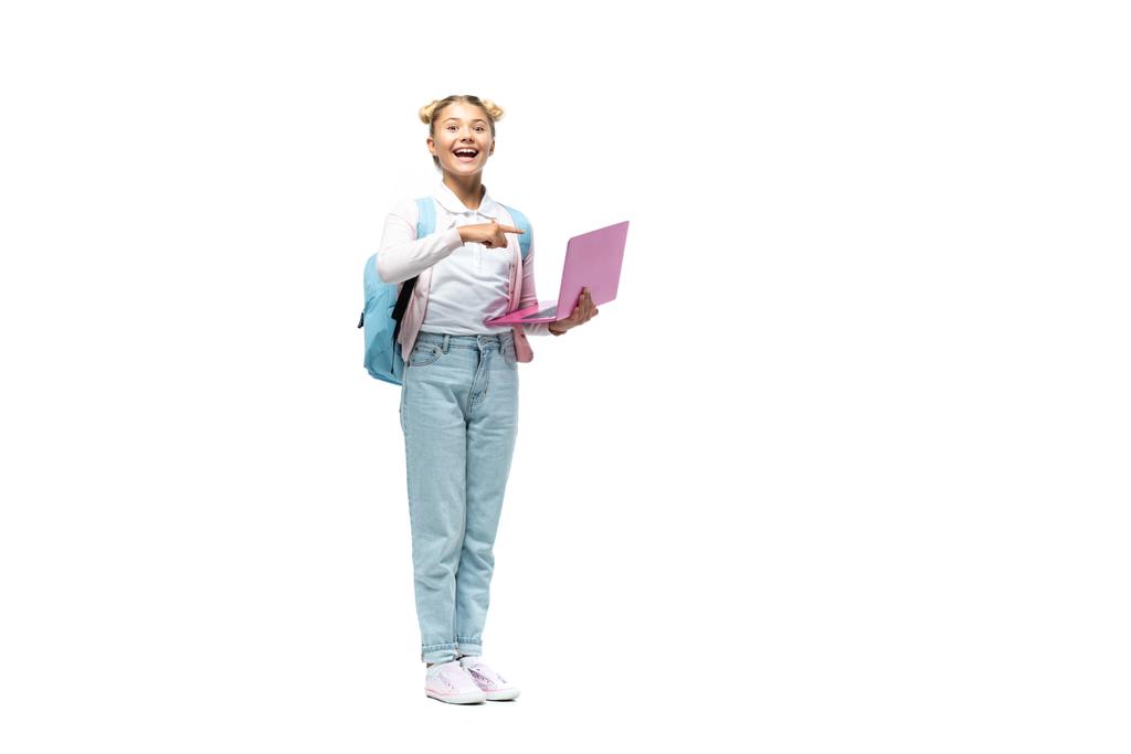 Nadšený školačka ukazuje prstem na notebook na bílém pozadí - Fotografie, Obrázek