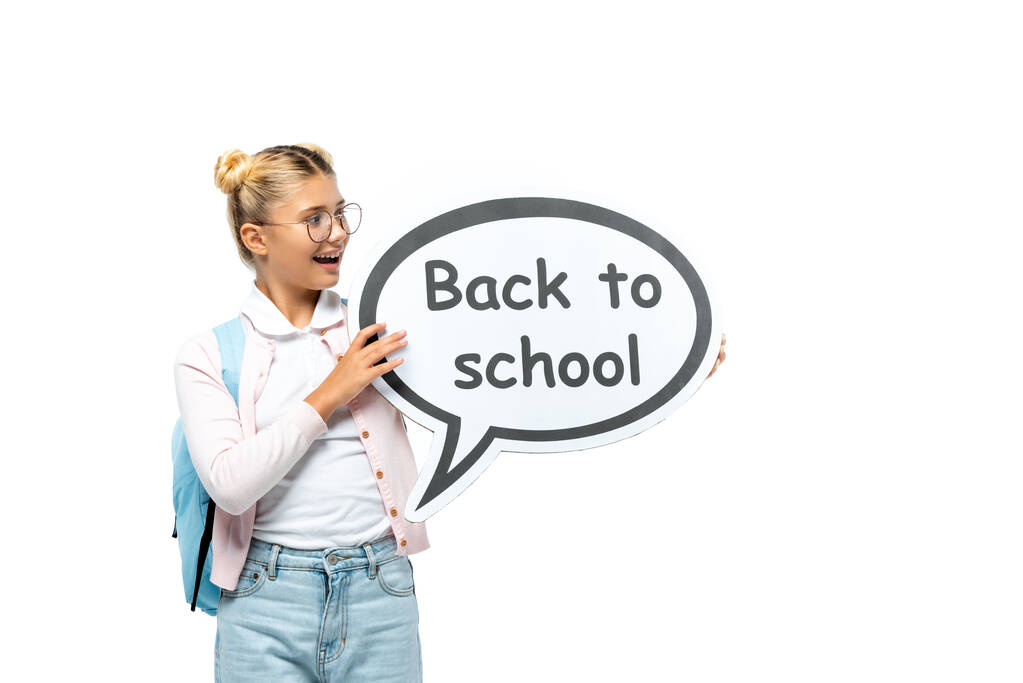 Школярка з рюкзаком, що тримає мовну бульбашку ззаду до школи, написи ізольовані на білому
  - Фото, зображення
