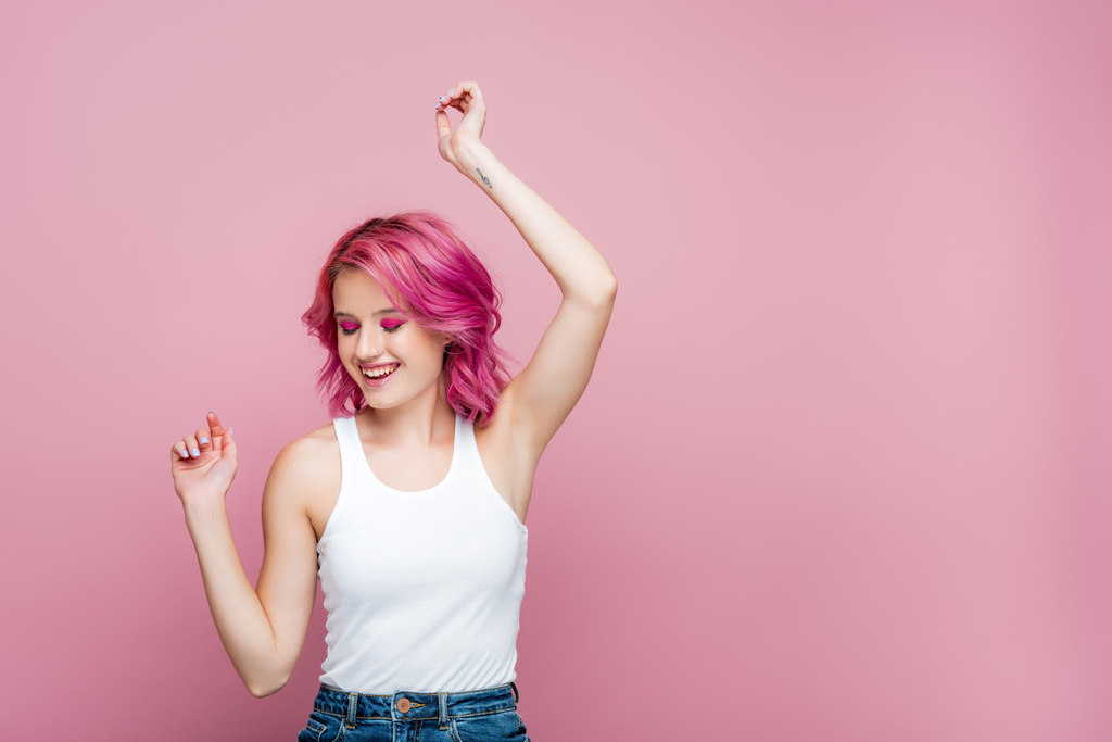 jovem mulher com cabelos coloridos gesticulando isolado em rosa - Foto, Imagem