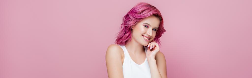 mujer joven con el pelo colorido sonriendo aislado en rosa, plano panorámico - Foto, Imagen
