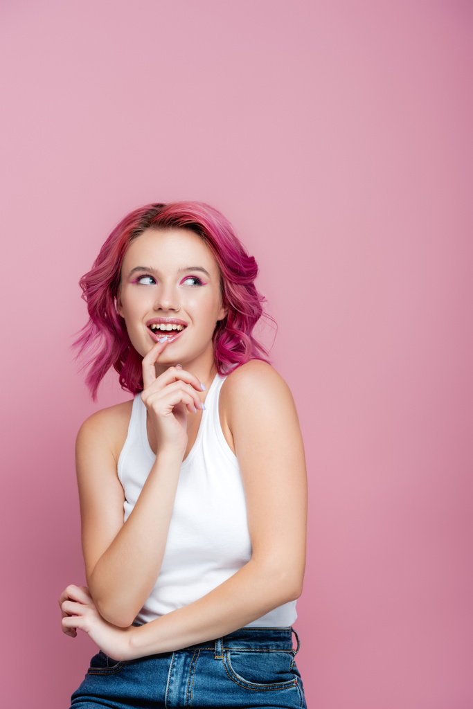 mladá žena s barevnými vlasy odvrací izolované na růžové - Fotografie, Obrázek