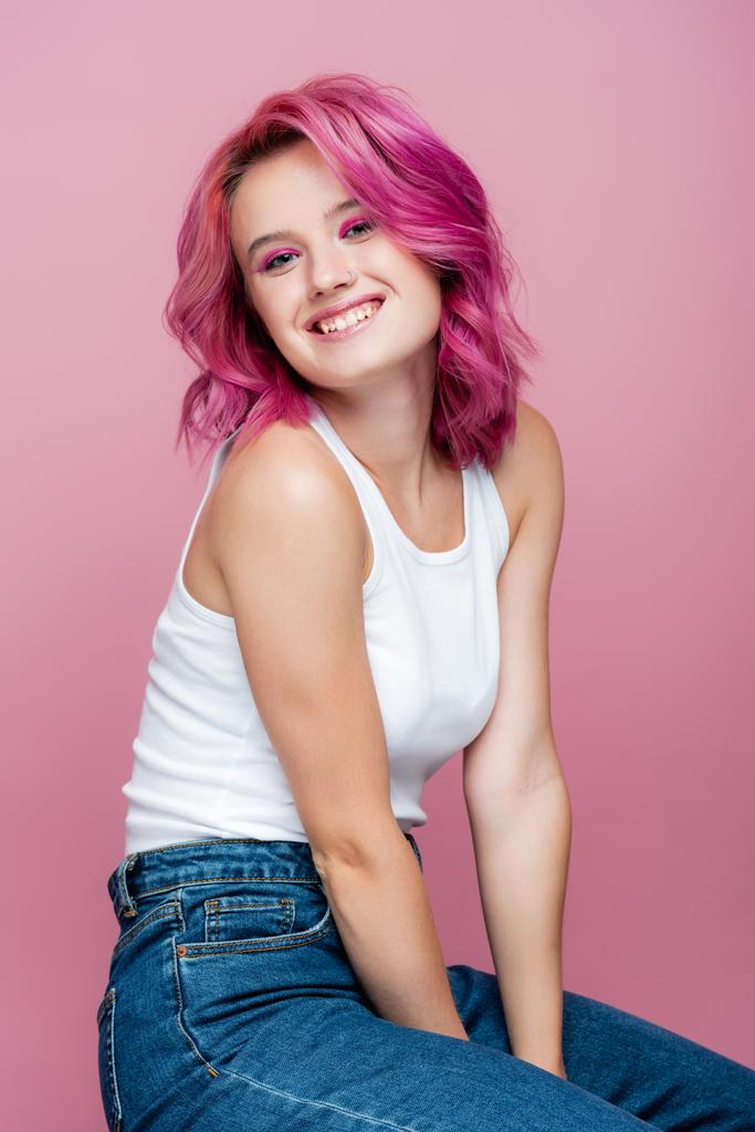 νεαρή γυναίκα με πολύχρωμα μαλλιά χαμογελώντας απομονωμένη σε ροζ - Φωτογραφία, εικόνα