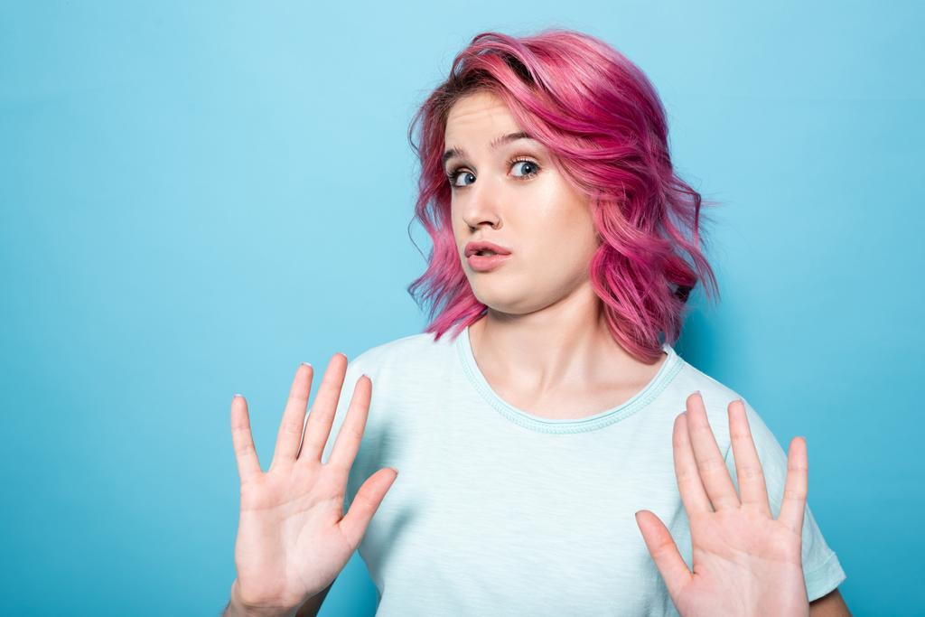 jovem mulher com cabelo rosa mostrando nenhum gesto no fundo azul - Foto, Imagem