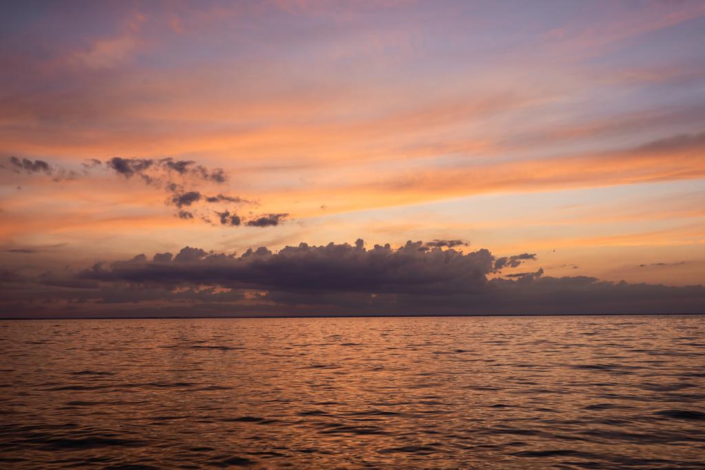 Пейзаж хмарного неба і моря на світанку
  - Фото, зображення