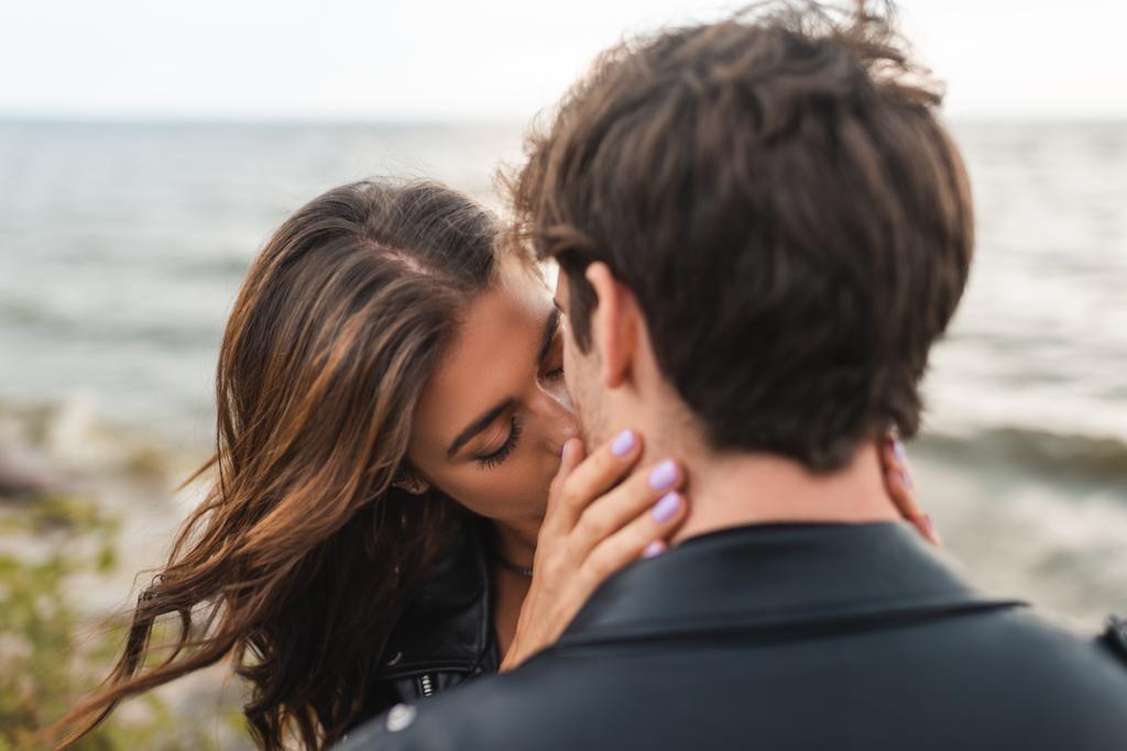 Selective focus of young woman kissing boyfriend on sea coast  - Photo, Image