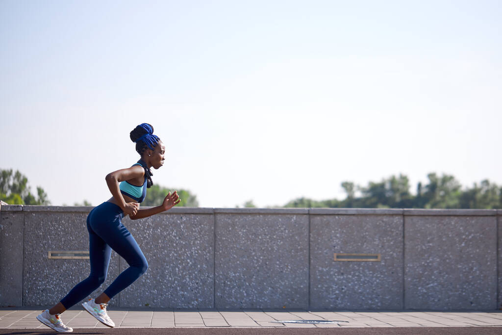 młody czarny fitness kobieta działa na stadionie - Zdjęcie, obraz