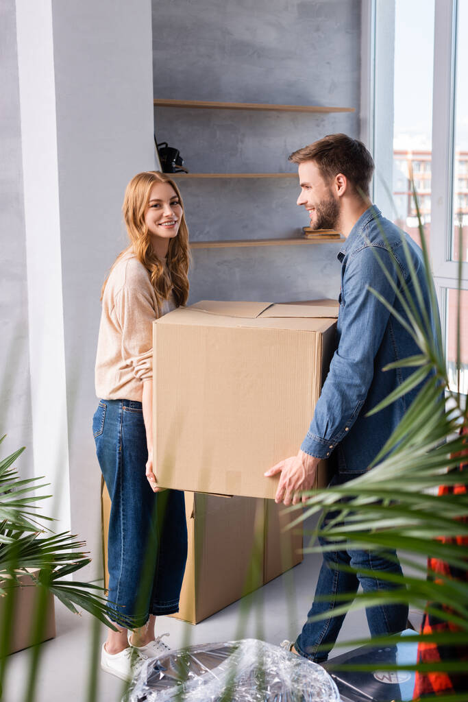 селективный фокус радостного мужчины и женщины с коробкой, движущаяся концепция - Фото, изображение