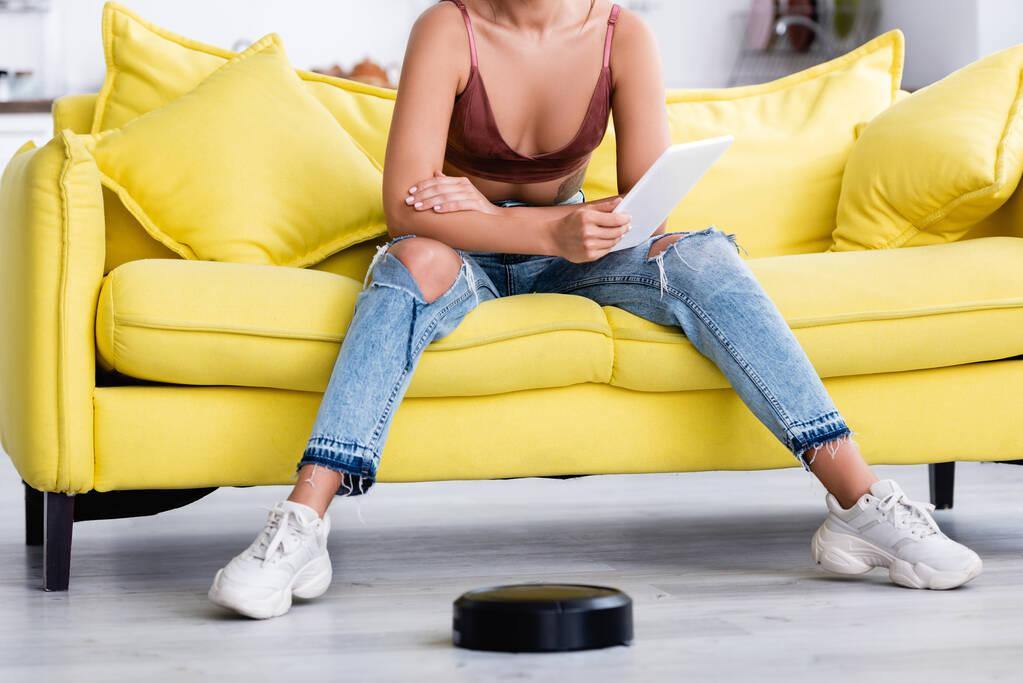 Cropped view of woman with digital tablet and robotic vacuum cleaner - Photo, Image