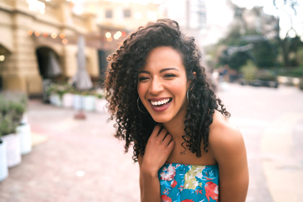 Портрет красивой афро-американской латинской самоуверенной женщины, смеющейся на улице. На открытом воздухе. - Фото, изображение