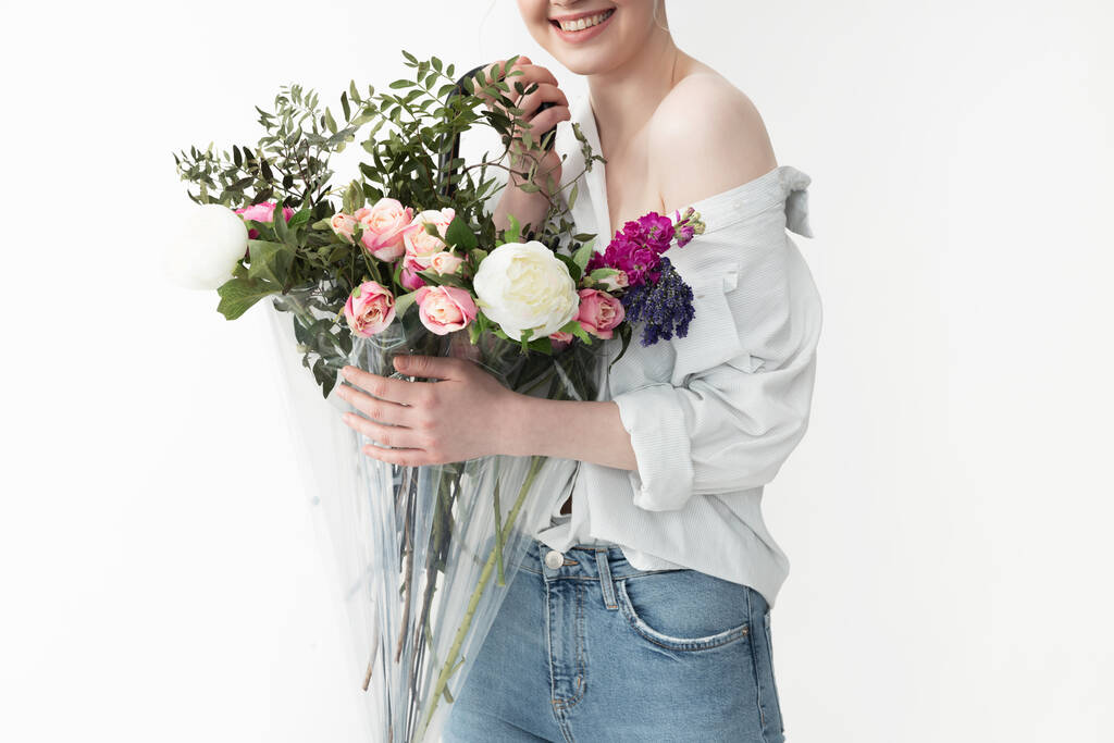 Smiling young woman holding umbrella with beautiful bouquet - Photo, Image
