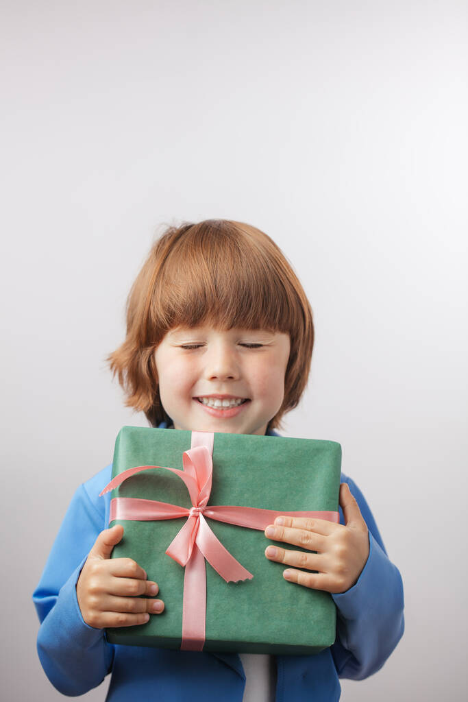 red-haired sweet boy is holding a box gift - Photo, Image