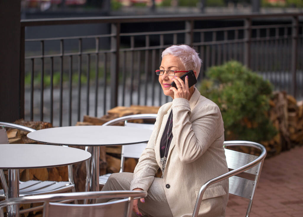 empresária positiva falando ao telefone em um café de rua - Foto, Imagem