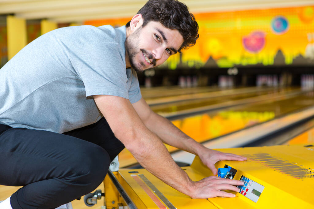 bowling werknemer manipuleren machine om de steegjes schoon te maken - Foto, afbeelding