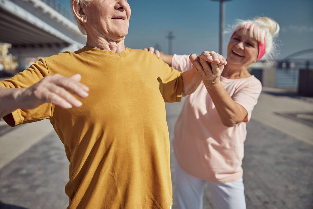 Homem idoso realizando um exercício de aquecimento ao ar livre - Foto, Imagem
