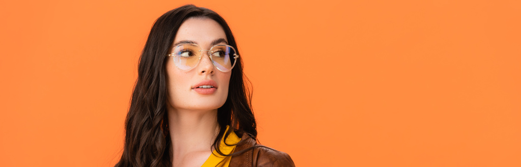 gözlüklü genç bir kadının panoramik mahsulü portakalda izole bir şekilde uzağa bakıyor.  - Fotoğraf, Görsel