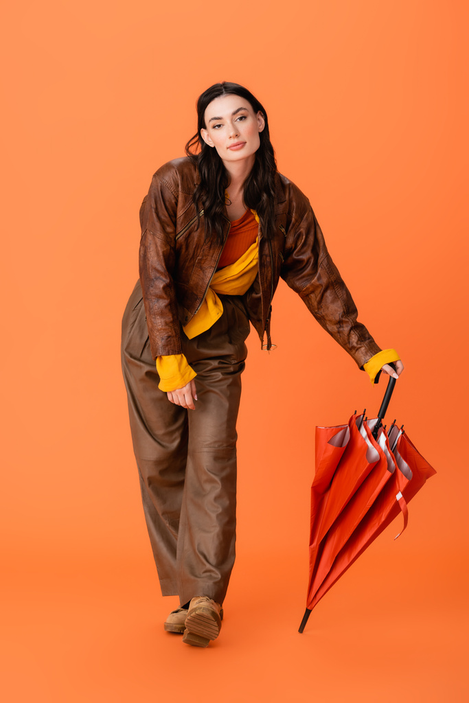 teljes hossza trendi fiatal nő őszi ruha és csizma álló esernyő narancs - Fotó, kép