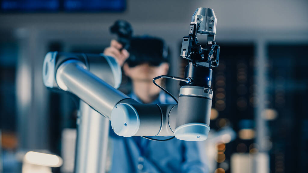 Detailní záběr na futuristickou robotickou paži řízenou profesionálním vývojovým inženýrem s virtuální realitou sluchátek a joysticků v High Tech Research Laboratory s moderním zařízením - Fotografie, Obrázek