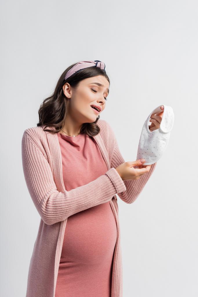 těhotné ženy při pohledu na malé dítě bryndáček izolované na bílém - Fotografie, Obrázek