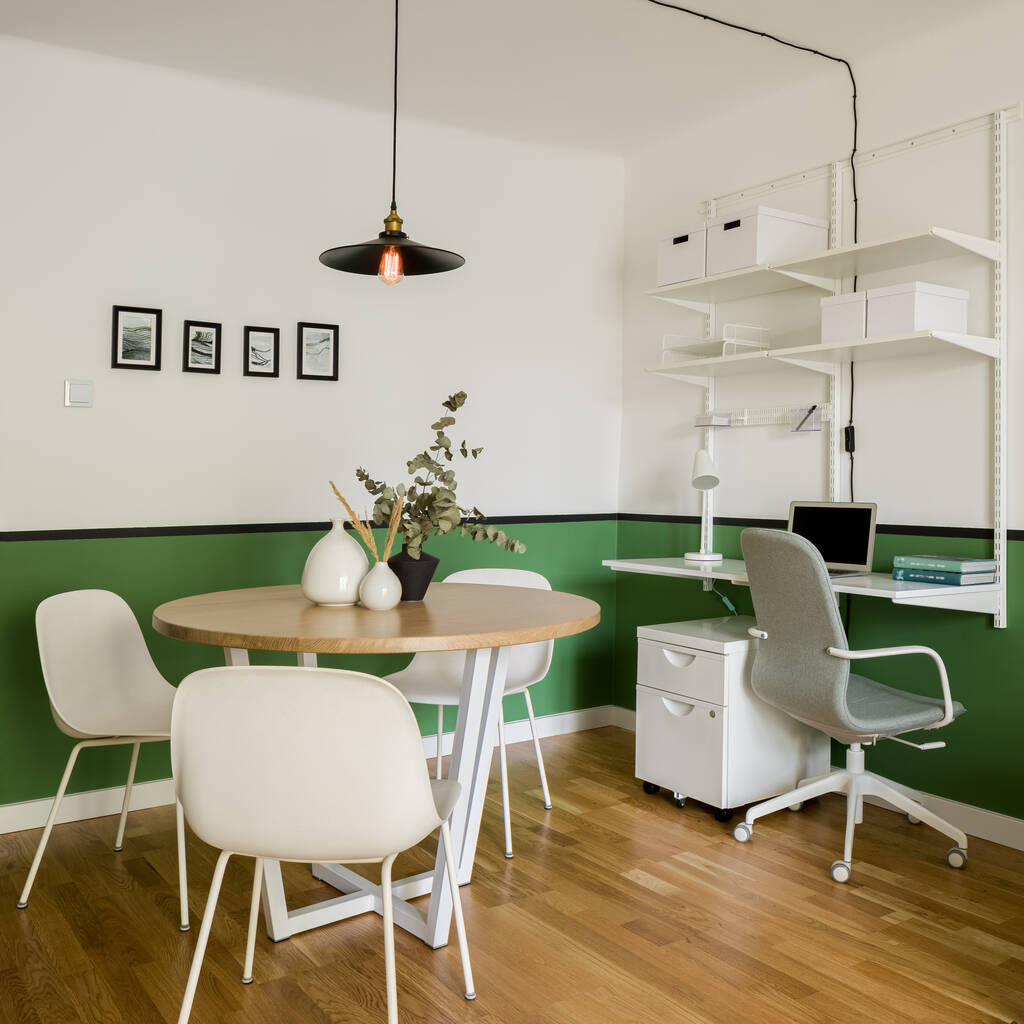Pequeño apartamento con mesa de comedor y sillas y oficina en casa con escritorio en una habitación con paredes verdes - Foto, Imagen