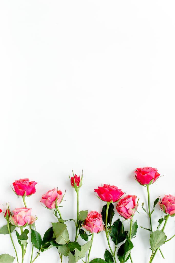 テキストのためのコピースペースと白い背景に赤いバラで作られた花の国境フレーム。バレンタインの背景。花柄。フラットレイアウト、トップビュー.  - 写真・画像