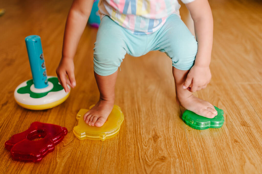 Retrato de un niño pequeño, niña, adorable bebé jugando pirámide de color en el suelo en el interior, juego de niños pequeños, juego en una habitación en casa o jardín de infantes. - Foto, imagen