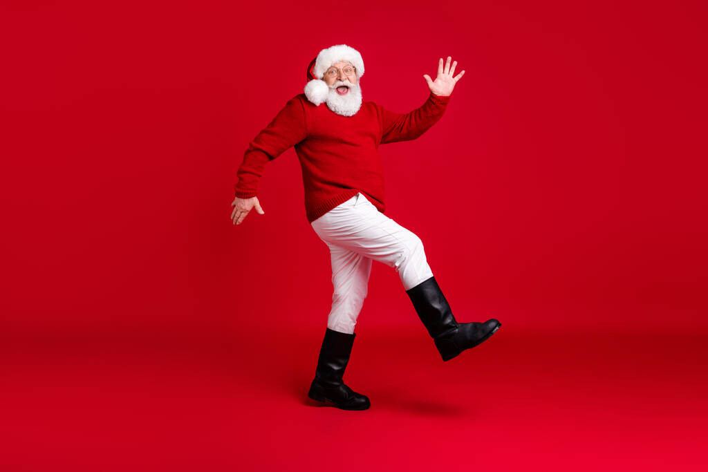 フルボディプロフィール側の写真面白い歳の男性退職年金受給者サンタクラスのヘッドウェアは、コピースペースを移動しますジョリーホリー伝統的なイベントは、 xマスの服のブーツは、孤立明るい輝きの色の背景を身に着けています - 写真・画像