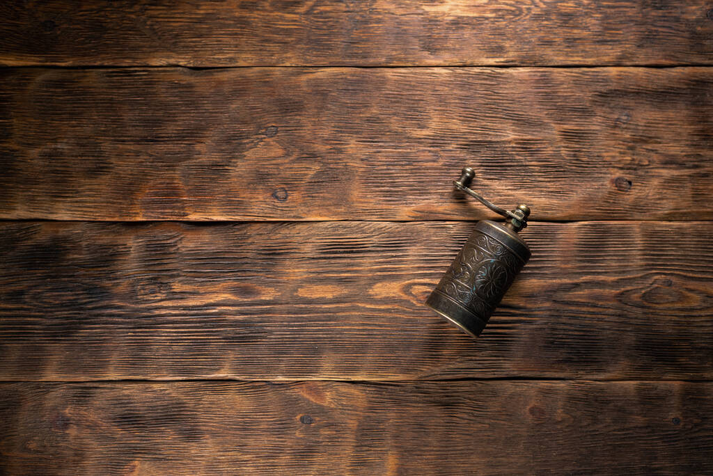 Невеликий перець млин на коричневому дерев'яному фоні столу з копіювальним простором
. - Фото, зображення