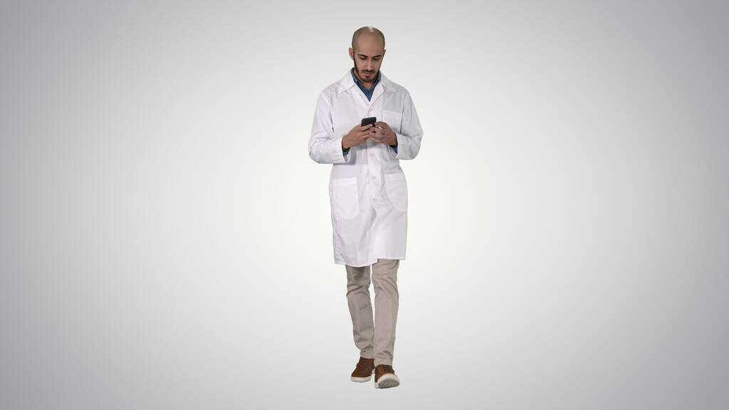 Мужчина арабский врач смс-ки по телефону во время прогулки по г - Фото, изображение