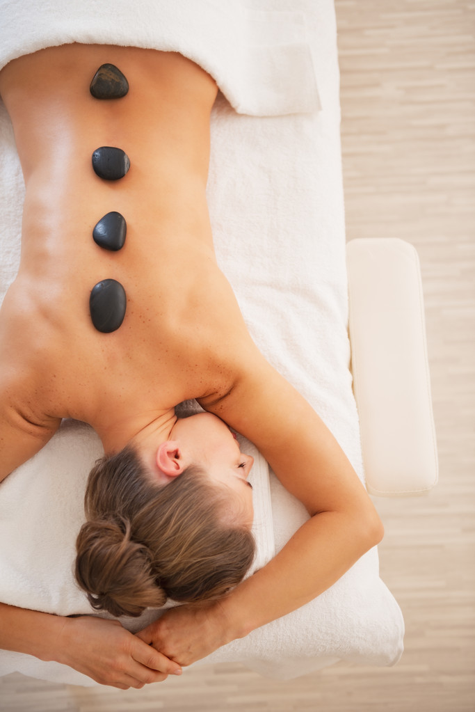Jeune femme recevant un massage aux pierres chaudes
 - Photo, image