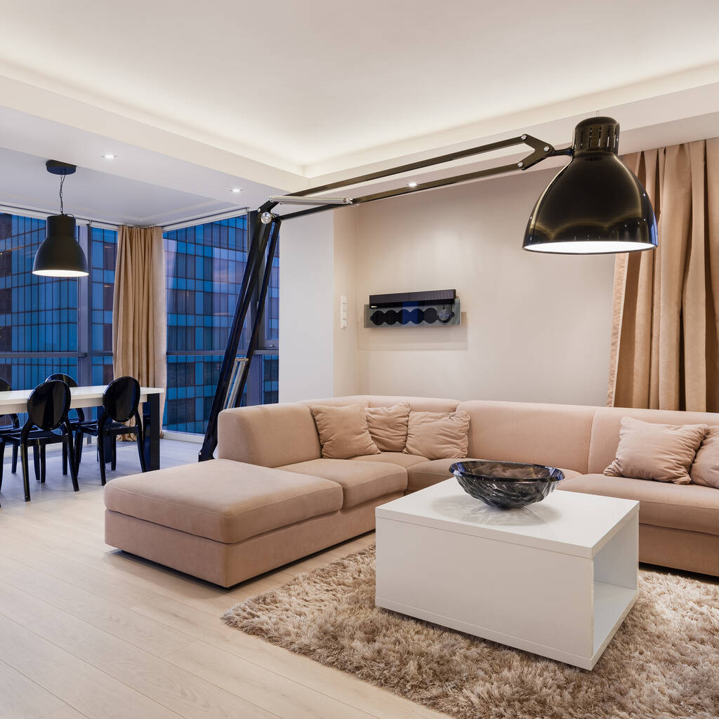 Elegante sala de estar com elegante, grande lâmpada preta acima sofá canto bege com mesa de café quadrado branco - Foto, Imagem