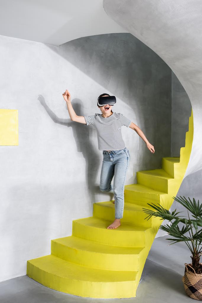 Femme en réalité virtuelle casque descendant les escaliers  - Photo, image