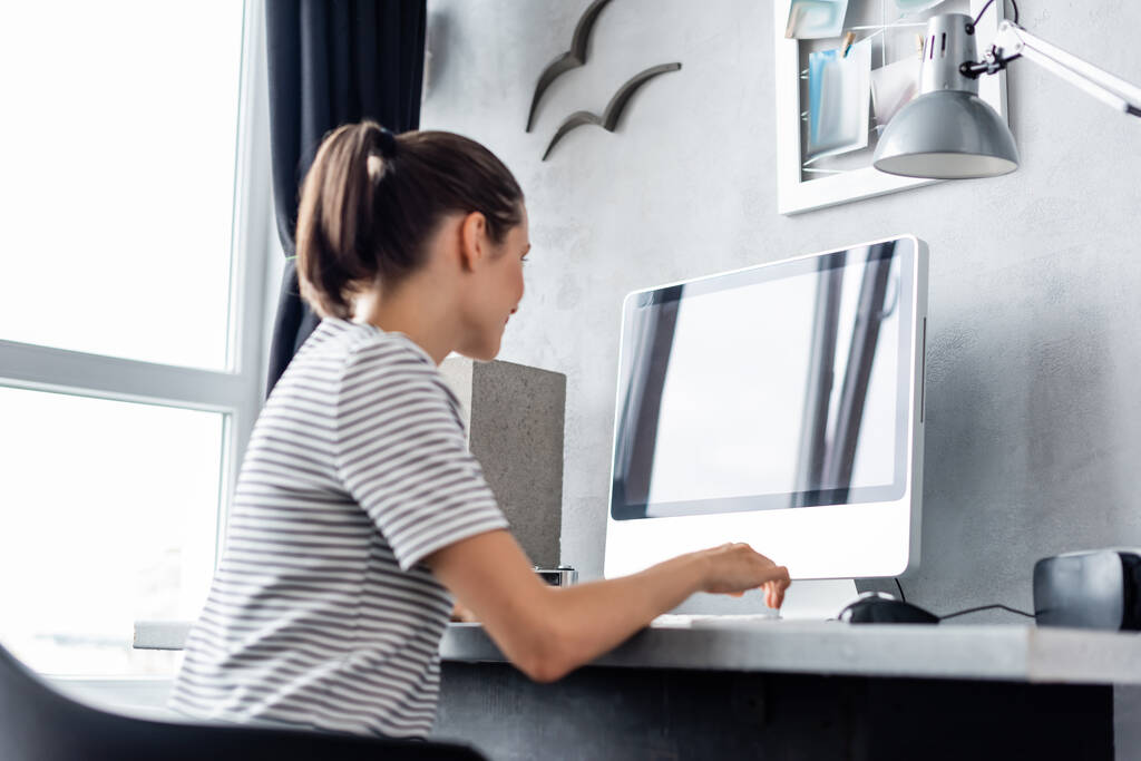 Concentration sélective des jeunes pigistes travaillant sur ordinateur près d'un casque vr à la maison  - Photo, image