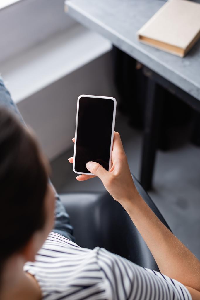 Junge Frau nutzt Smartphone mit leerem Bildschirm zu Hause  - Foto, Bild