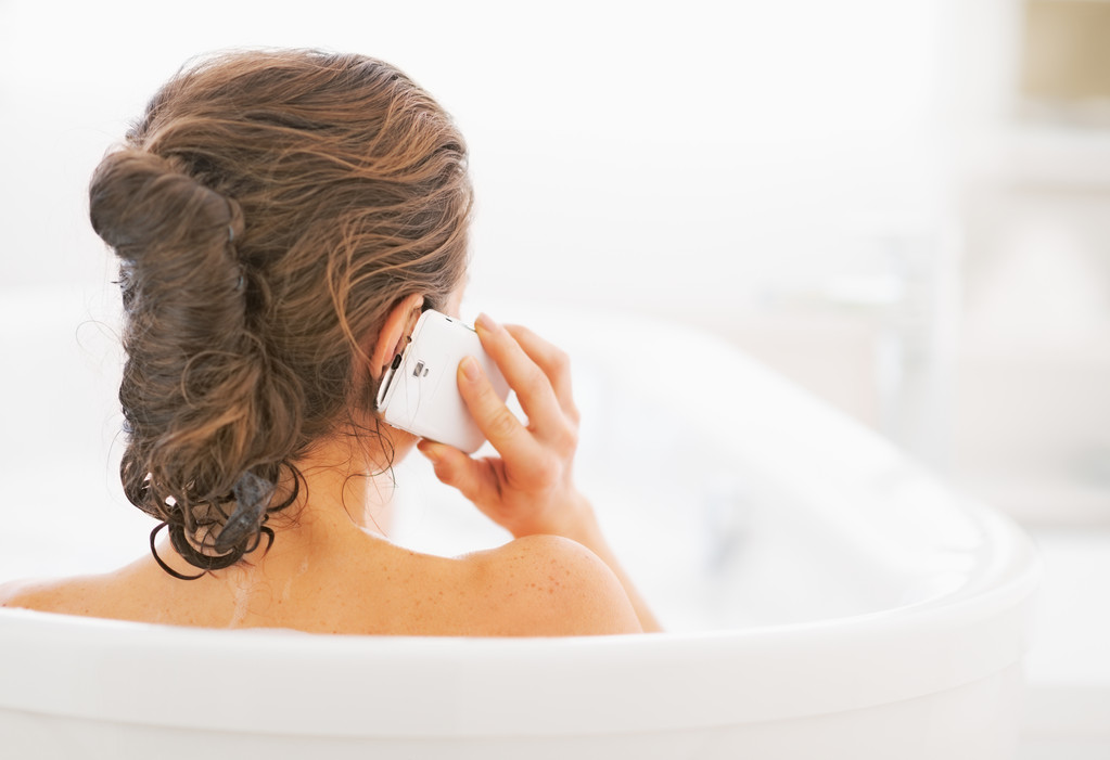 Jovem mulher na banheira falando telefone celular
 - Foto, Imagem