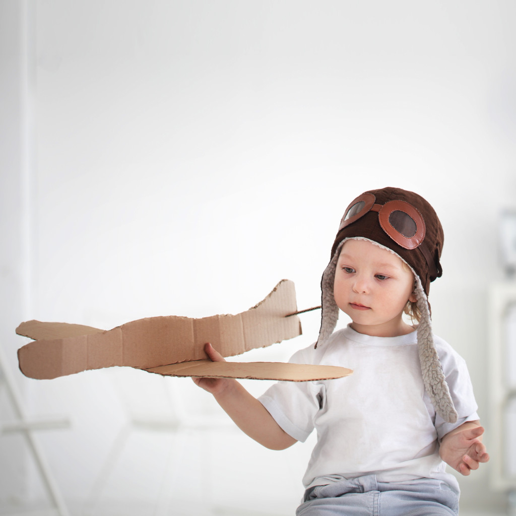 gelukkige jongen spelen in vliegtuig binnenshuis - Foto, afbeelding