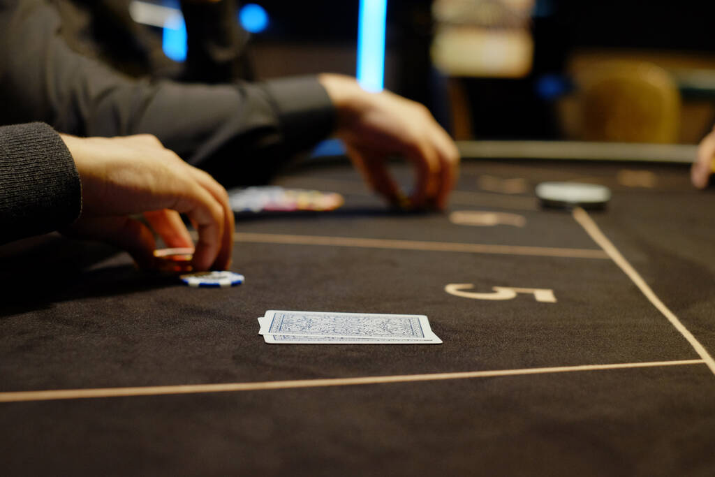 ディーラーやクルッパーは、テーブル、チップの背景にカジノでポーカーカードをシャッフルします。ポーカーゲーム、ゲームビジネスの概念。お金のために遊ぶ、大きな勝利、ジャックポット、ギャンブル、金持ちになりたいという願望. - 写真・画像