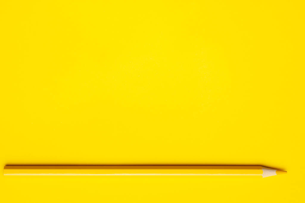 matita di legno affilato giallo orizzontale su uno sfondo giallo brillante, isolato, copiare spazio, modellare - Foto, immagini