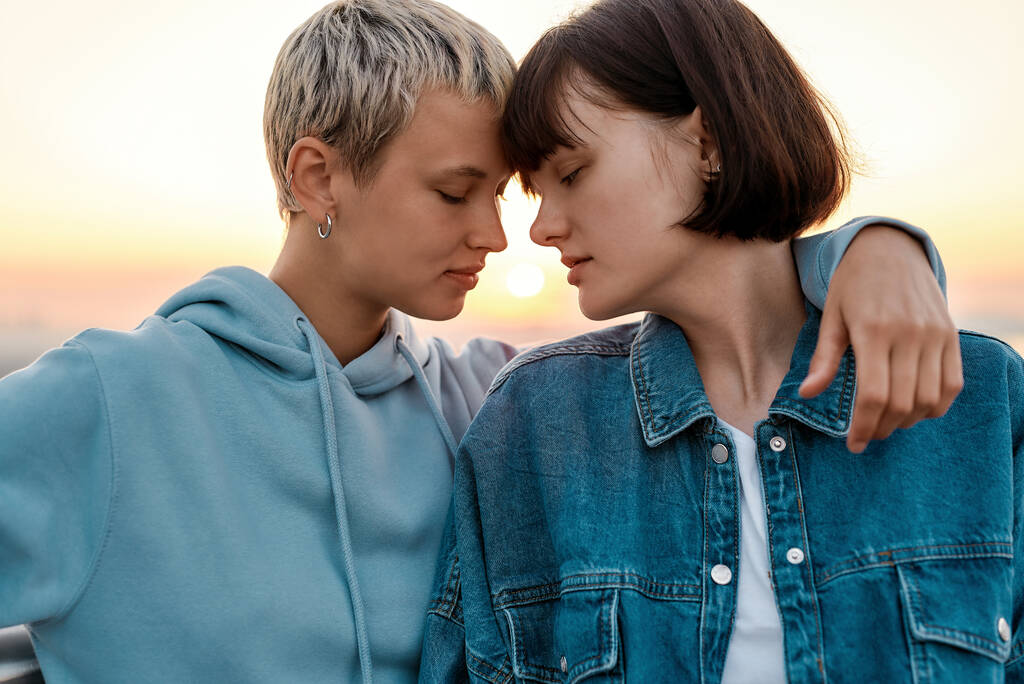 Κοντινό πλάνο των νέων αισθησιακό λεσβιακό ζευγάρι πρόκειται να φιλήσει, δύο γυναίκες απολαμβάνουν ρομαντικές στιγμές μαζί κατά την ανατολή του ηλίου - Φωτογραφία, εικόνα