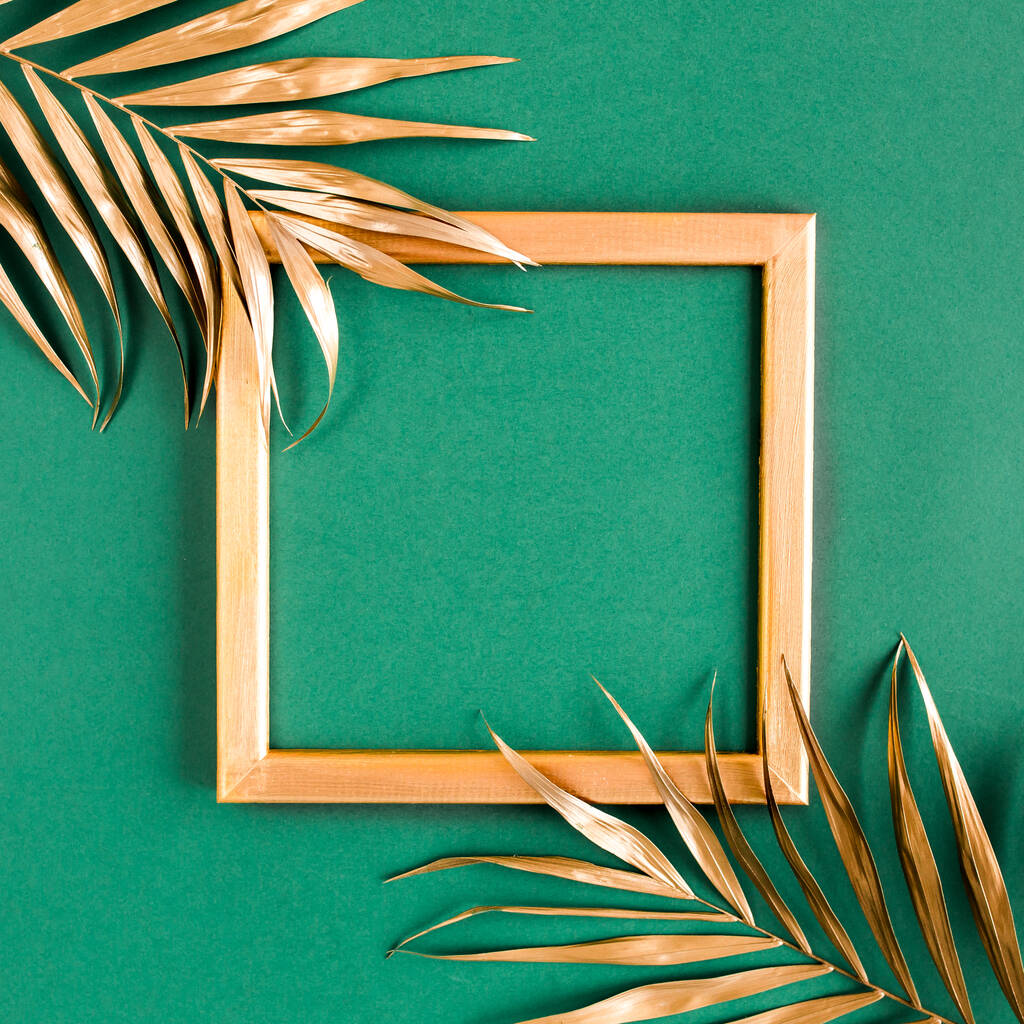 Золотые тропические пальмовые листья и рамка на зеленом фоне. Плоская кладка, вид сверху минимальная концепция. - Фото, изображение