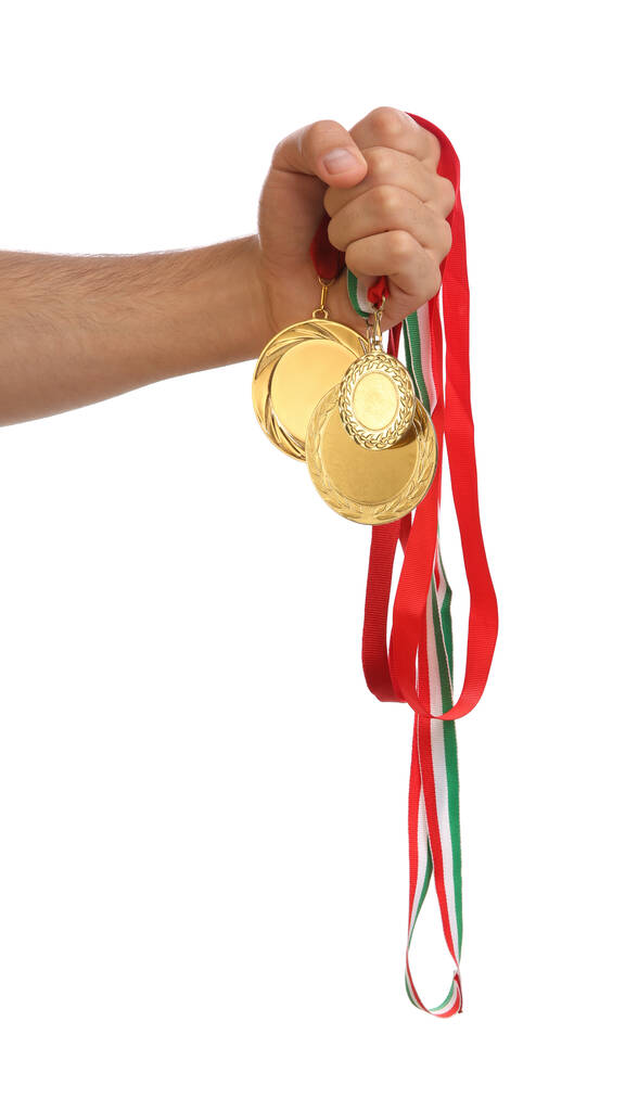 Чоловік тримає золоті медалі на білому тлі, крупним планом. Простір для дизайну
 - Фото, зображення