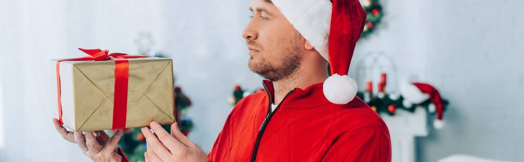 サンタ・ハットの男のパノラマ写真クリスマスプレゼント箱を持って - 写真・画像