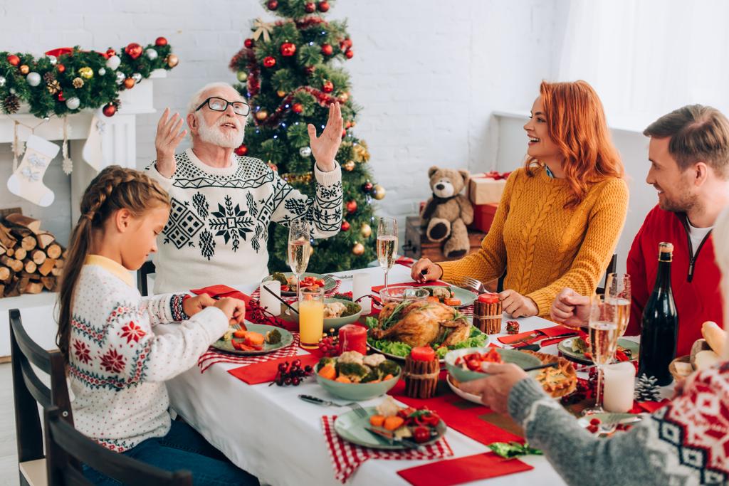 Rodzina siedzi przy świątecznym stole z dziękczynną kolacją przy kominku w domu - Zdjęcie, obraz