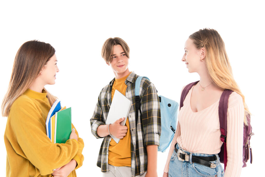 Adolescentes con mochilas y cuadernos sonriéndose aislados en blanco - Foto, imagen