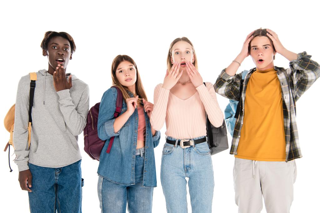 Aufgeregte multikulturelle Teenager mit Rucksäcken blicken vereinzelt in die Kamera - Foto, Bild