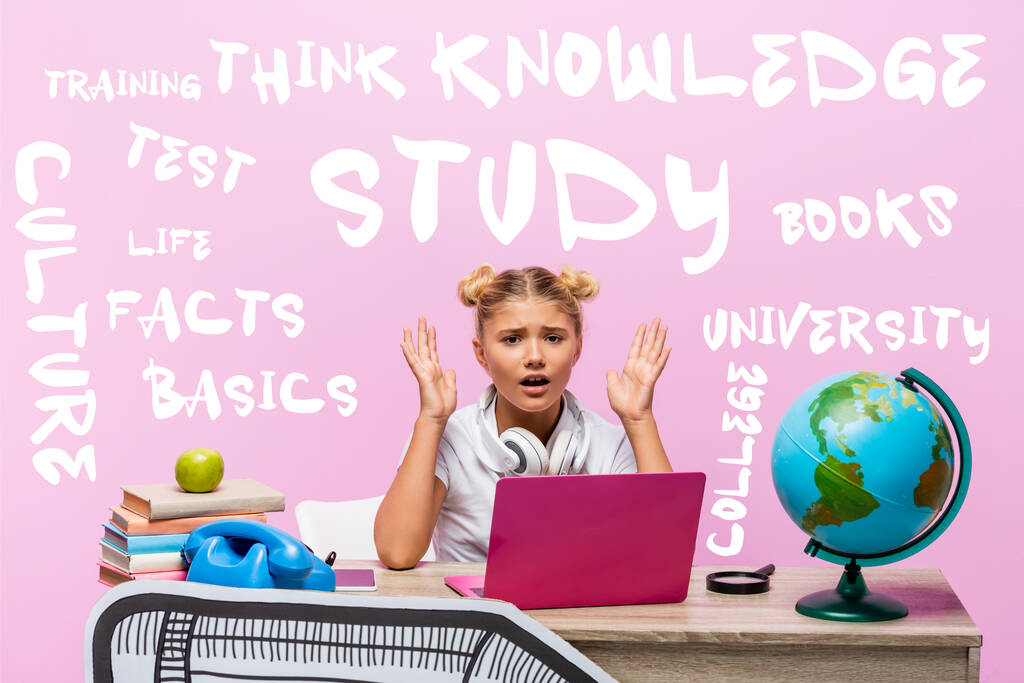 Besorgtes Kind blickt in die Kamera neben Laptop, Büchern, Papierkunst, Globus, Retro-Telefon und Schriftzug auf rosa  - Foto, Bild