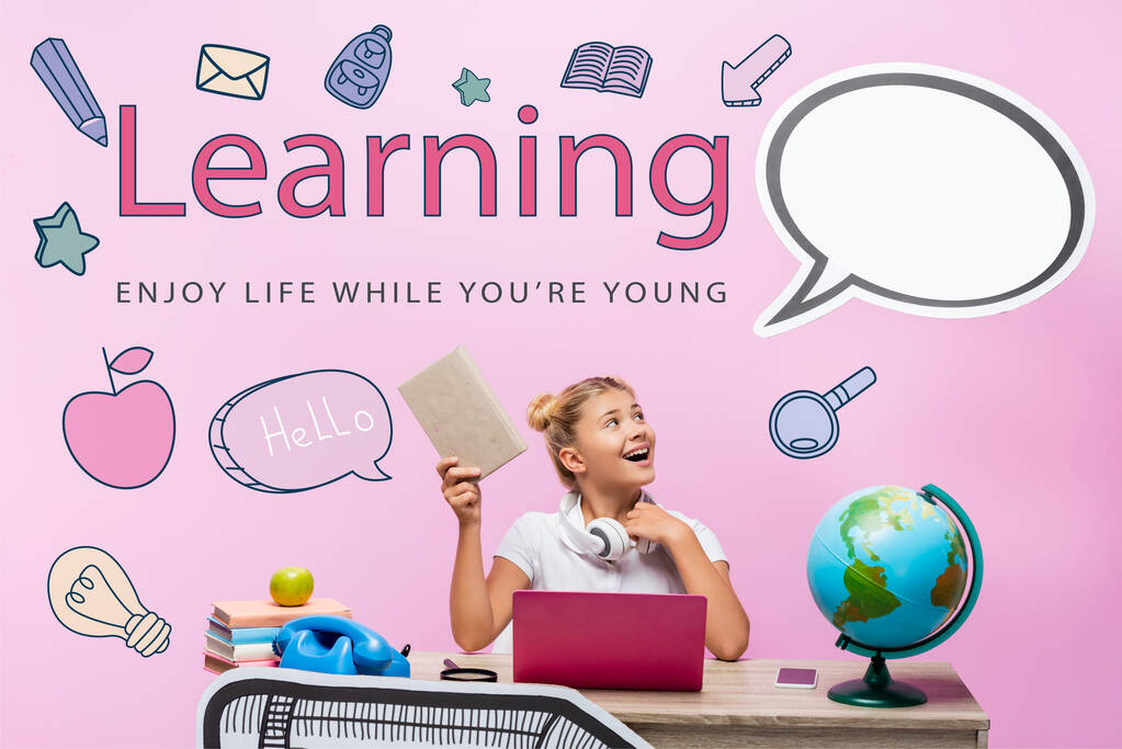 Schoolgirl holding book and looking at blank speech bubble near gadgets, globe and learning, enjoy life while you are young lettering on pink  - Photo, Image