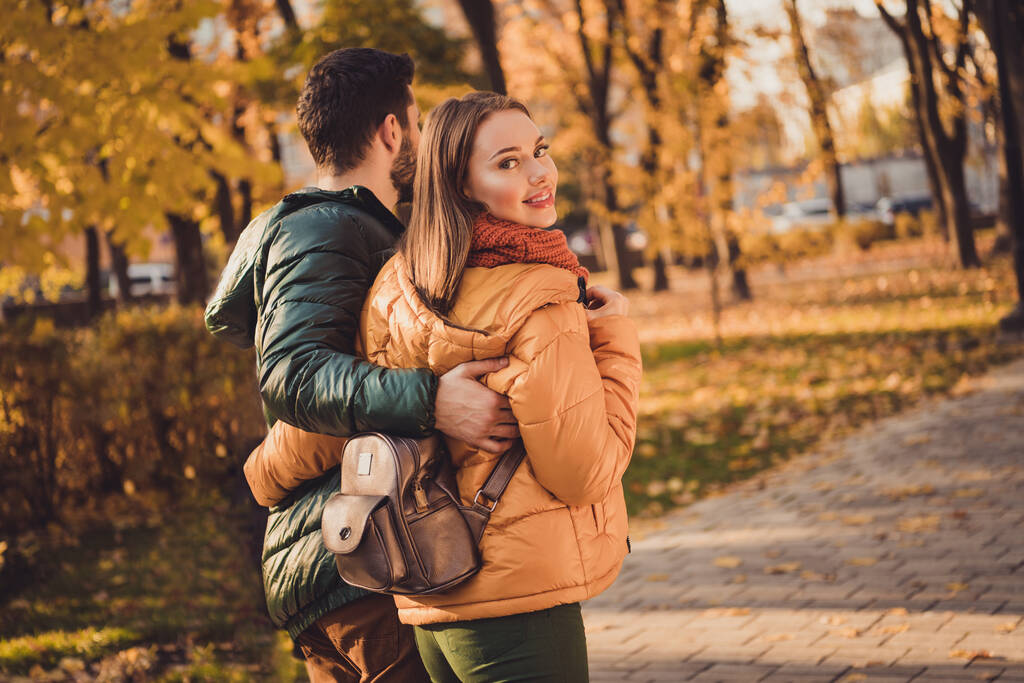 Задній вид на хребет фотографія гармонії романтичної пари, що йде в жовтні осінній лісовий міський парк, обіймаючи пальто
 - Фото, зображення